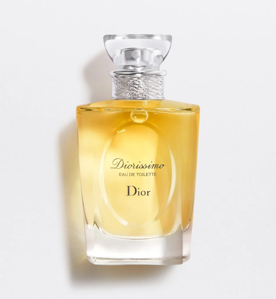 A bottle of Dior Diorissimo perfume. The color is yellow with a sparkle bottle neck and clear cap. Diorissimo is written is a cursive font