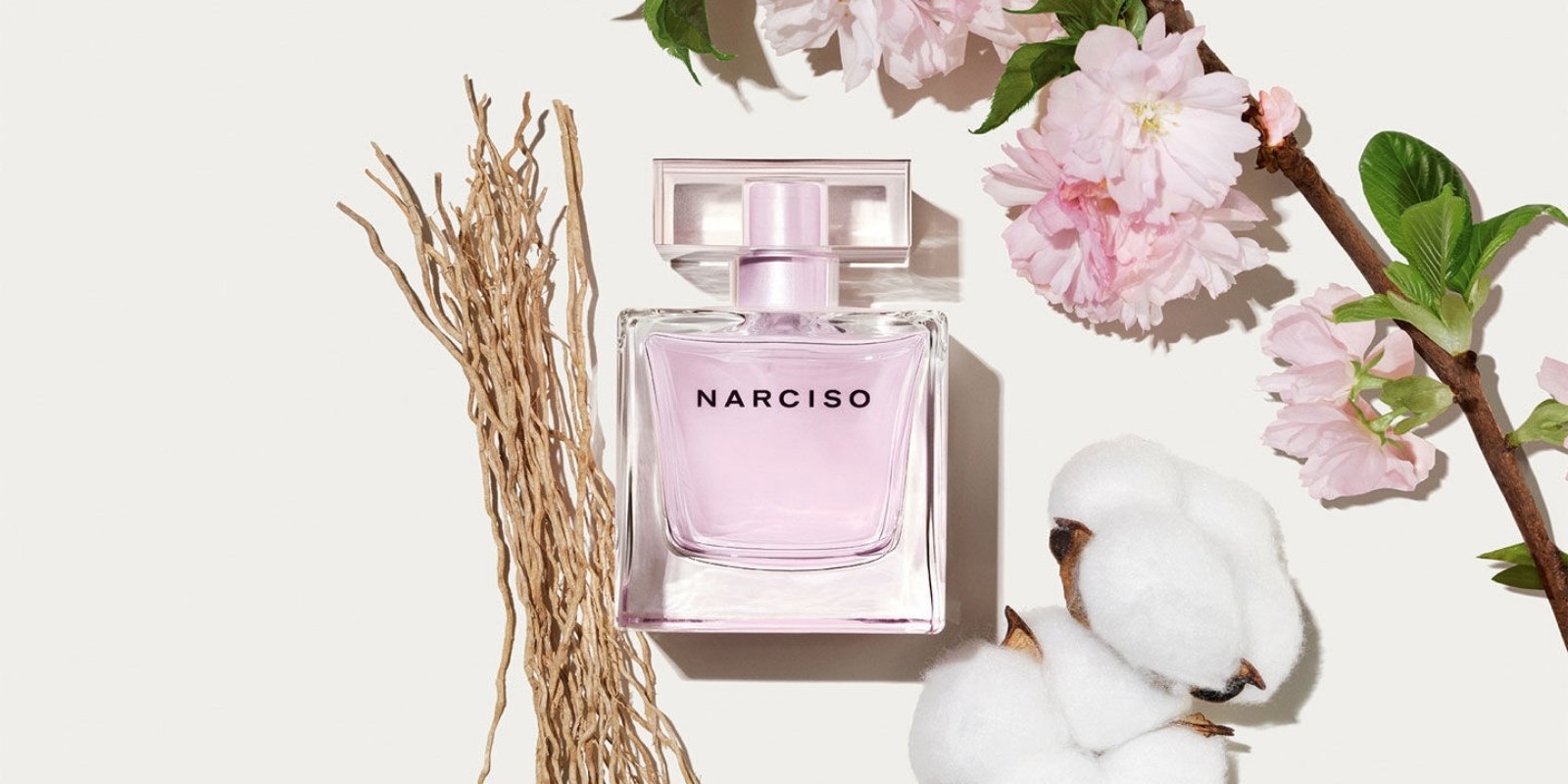 clean girl perfume 'Narciso Radiante' surrounded by white vetiver, cotton blossom, and pink flowers