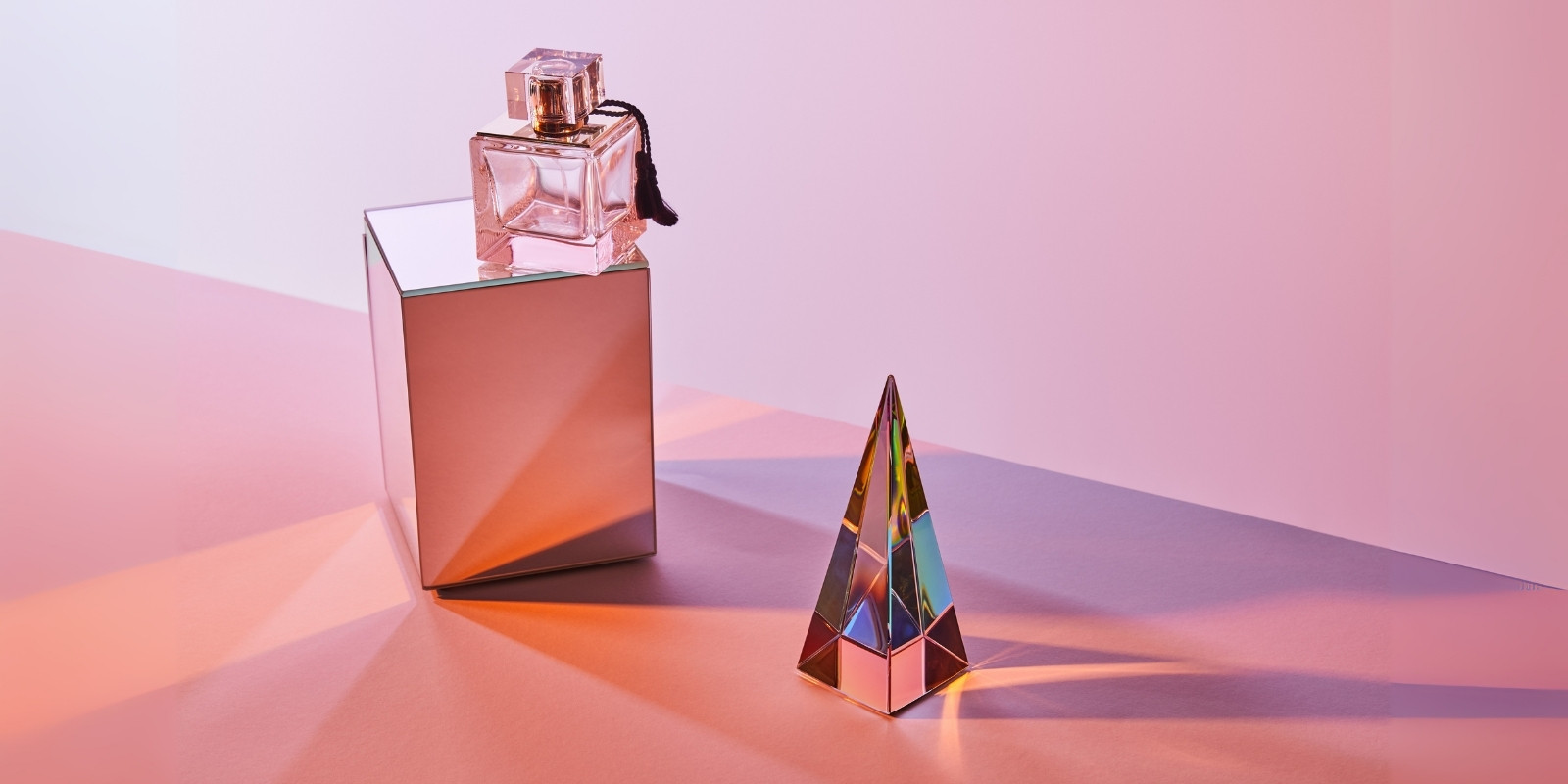 An image of a perfume bottle and a pyramid nearby