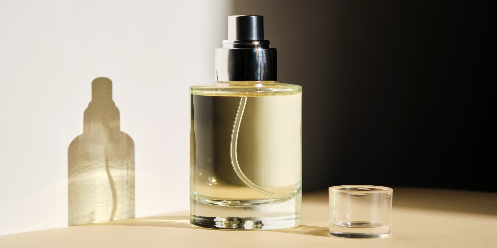 An image of a perfume bottle placed against a wall